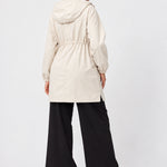 Back view of Ingrid & Isabel All-Weather Anorak Maternity Jacket in stone on a pregnant model.