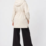 Back view of Ingrid & Isabel All-Weather Anorak Maternity Jacket in stone on a pregnant model.