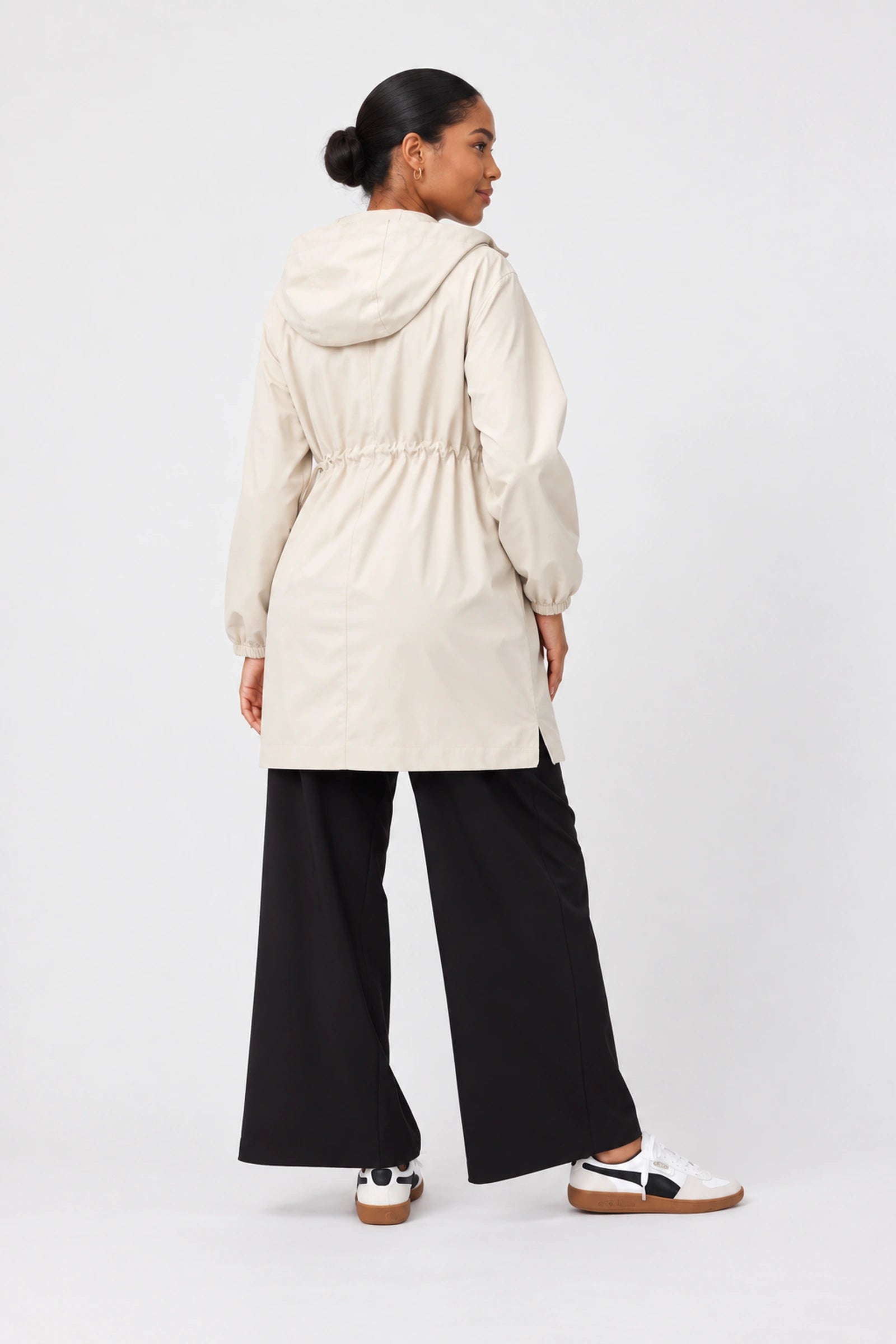 Back view of Ingrid & Isabel All-Weather Anorak Maternity Jacket in stone on a pregnant model.