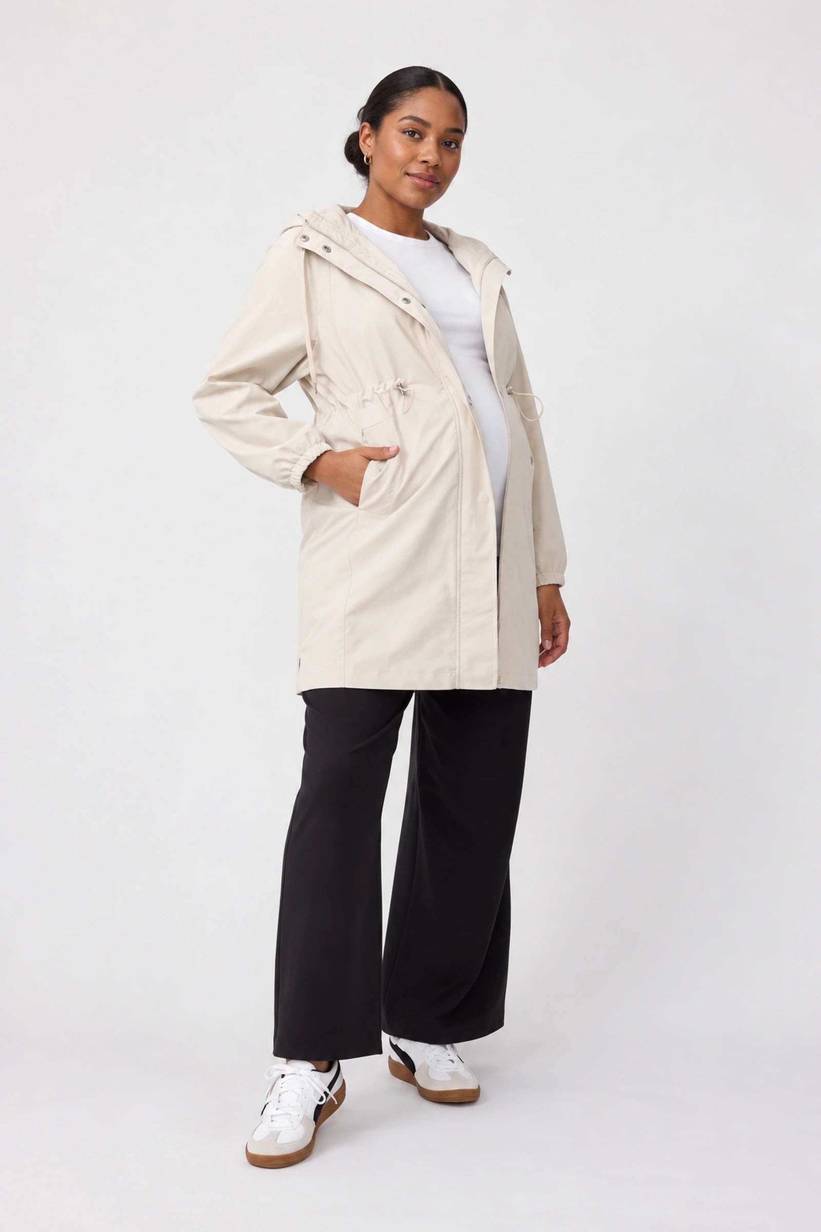 Front view of Ingrid & Isabel All-Weather Anorak Maternity Jacket in stone on a pregnant model.