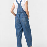 Back view of Ingrid & Isabel Everyday Denim Maternity Overalls in medium wash on a pregnant model.