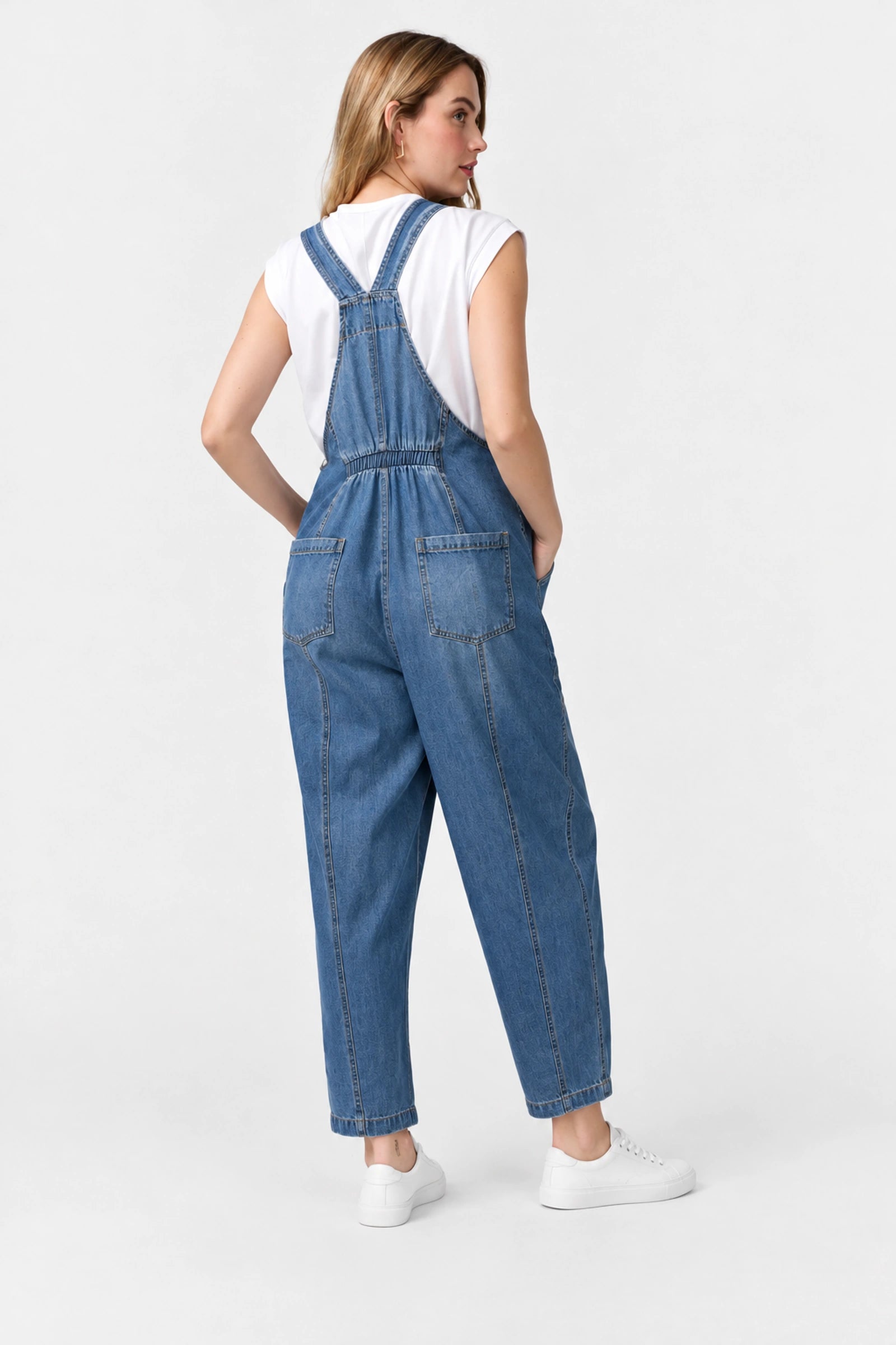 Back view of Ingrid & Isabel Everyday Denim Maternity Overalls in medium wash on a pregnant model.