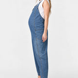 Side view of Ingrid & Isabel Everyday Denim Maternity Overalls in medium wash on a pregnant model.