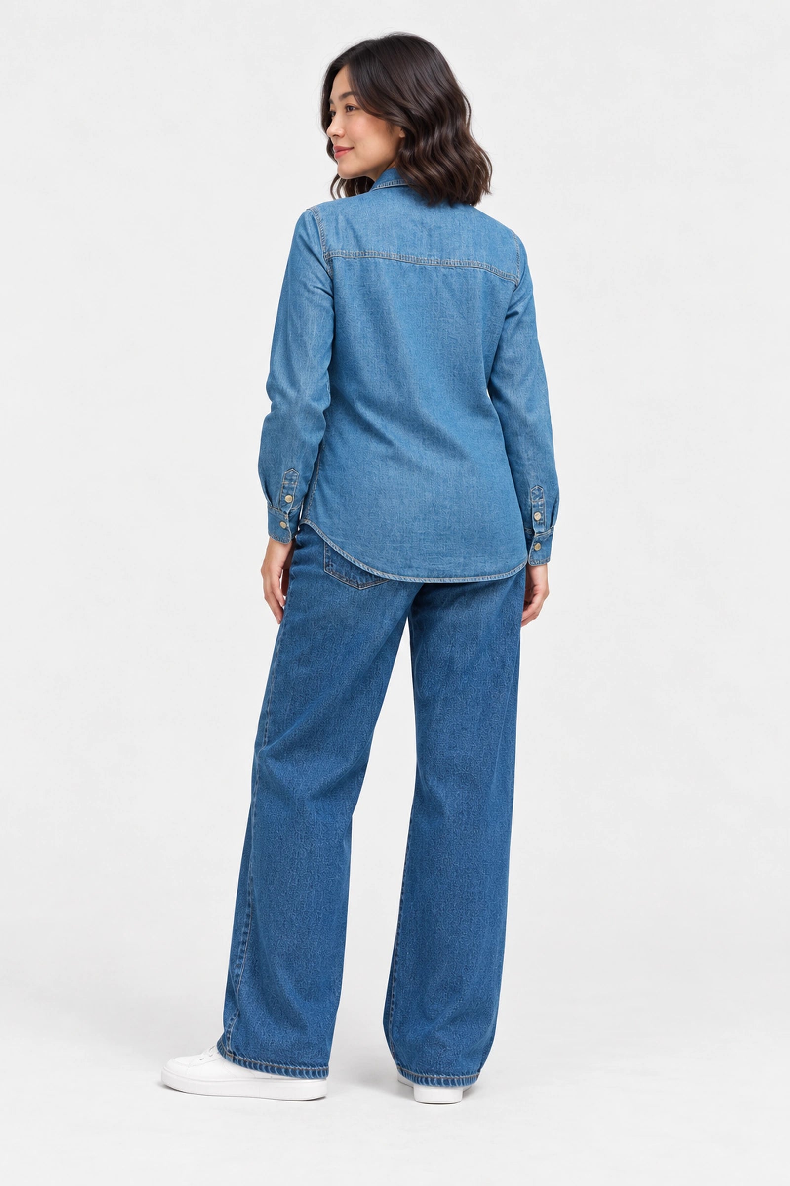 Back view of Ingrid & Isabel Relaxed Denim Maternity + Nursing Shirt in medium wash on a pregnant model.