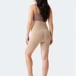 Back view of Ingrid & Isabel Seamless Maternity Shapewear Shortie in taupe on a pregnant model.
