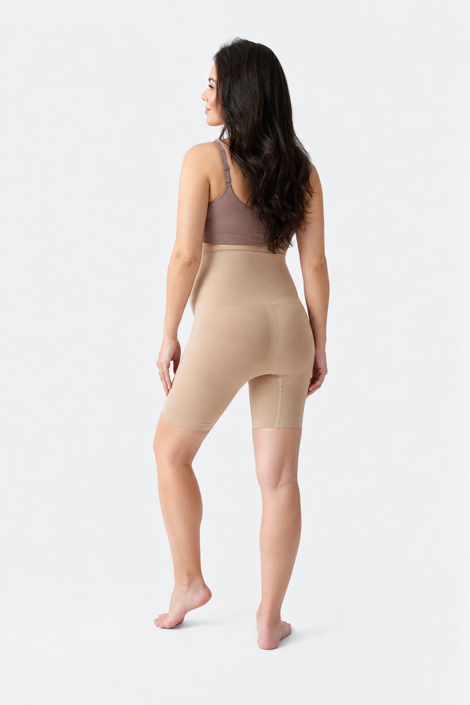 Back view of Ingrid & Isabel Seamless Maternity Shapewear Shortie in taupe on a pregnant model.