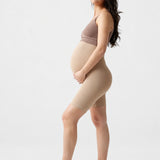 Side view of Ingrid & Isabel Seamless Maternity Shapewear Shortie in taupe on a pregnant model.