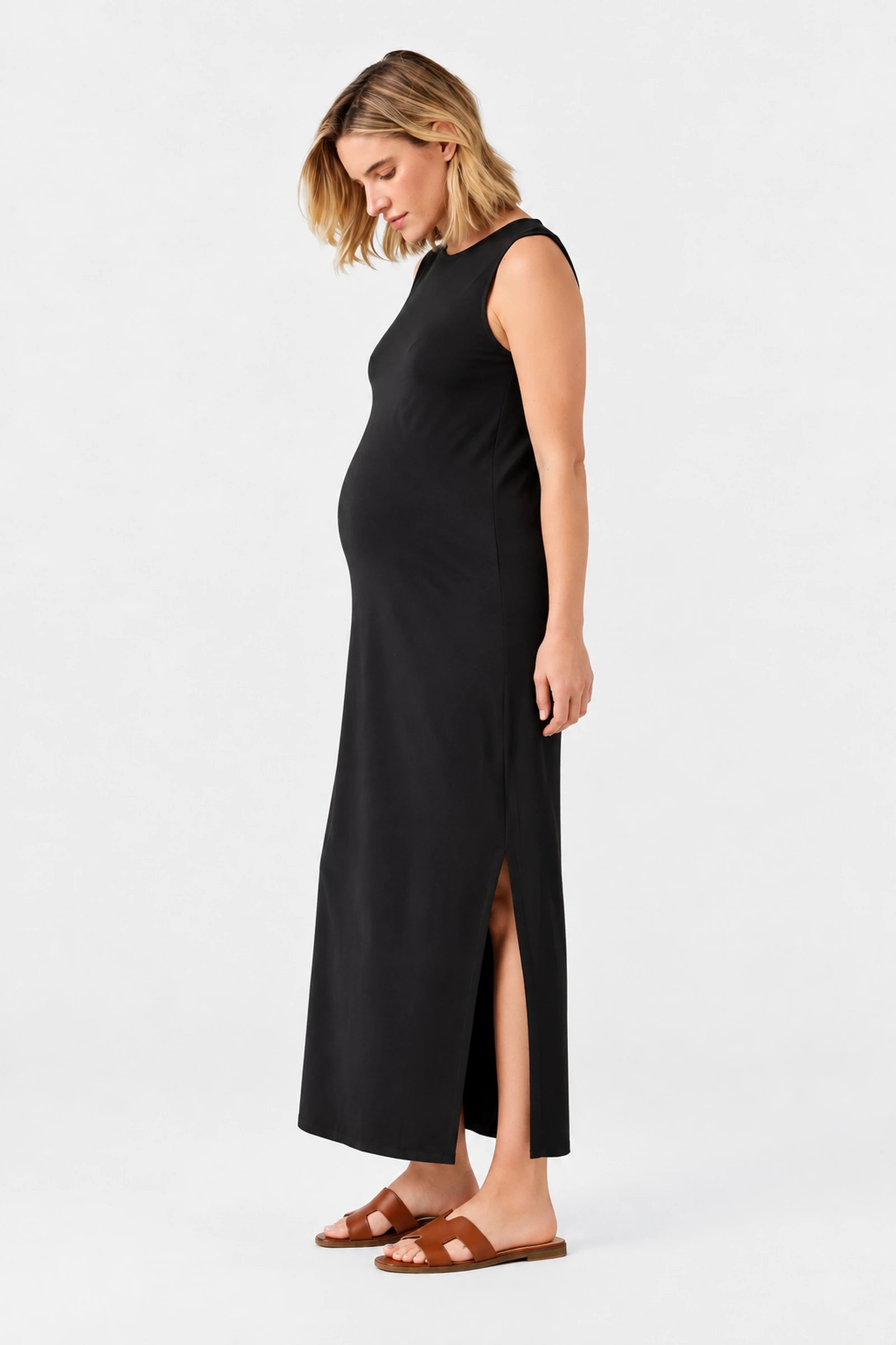 Side view of Ingrid & Isabel The Sidekick Maternity Column Dress in black on a pregnant model.