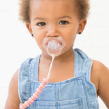 Baby with pacifier attached to clothes via pink silicone bead pacifier clip