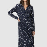 Spot shirt dress in navy with white polka dots. For maternity and nursing with button access for nursing and tie empire waist. Long sleeves and calf-length dress cut. 
