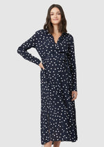 Spot shirt dress in navy with white polka dots. For maternity and nursing with button access for nursing and tie empire waist. Long sleeves and calf-length dress cut. 