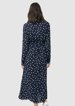 Detail of back of Spot shirt dress in navy with white polka dots. For maternity and nursing with button access for nursing and tie empire waist. Long sleeves and calf-length dress cut. 