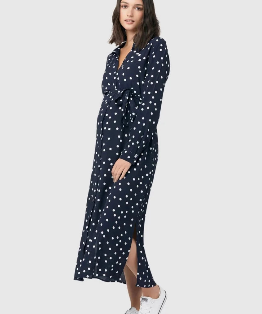 Spot shirt dress in navy with white polka dots. For maternity and nursing with button access for nursing and tie empire waist. Long sleeves and calf-length dress cut. 