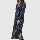 Spot shirt dress in navy with white polka dots. For maternity and nursing with button access for nursing and tie empire waist. Long sleeves and calf-length dress cut. 