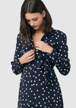 Detail showing nursing access buttons at bodice on Spot shirt dress in navy with white polka dots. For maternity and nursing with button access for nursing and tie empire waist. Long sleeves and calf-length dress cut. 
