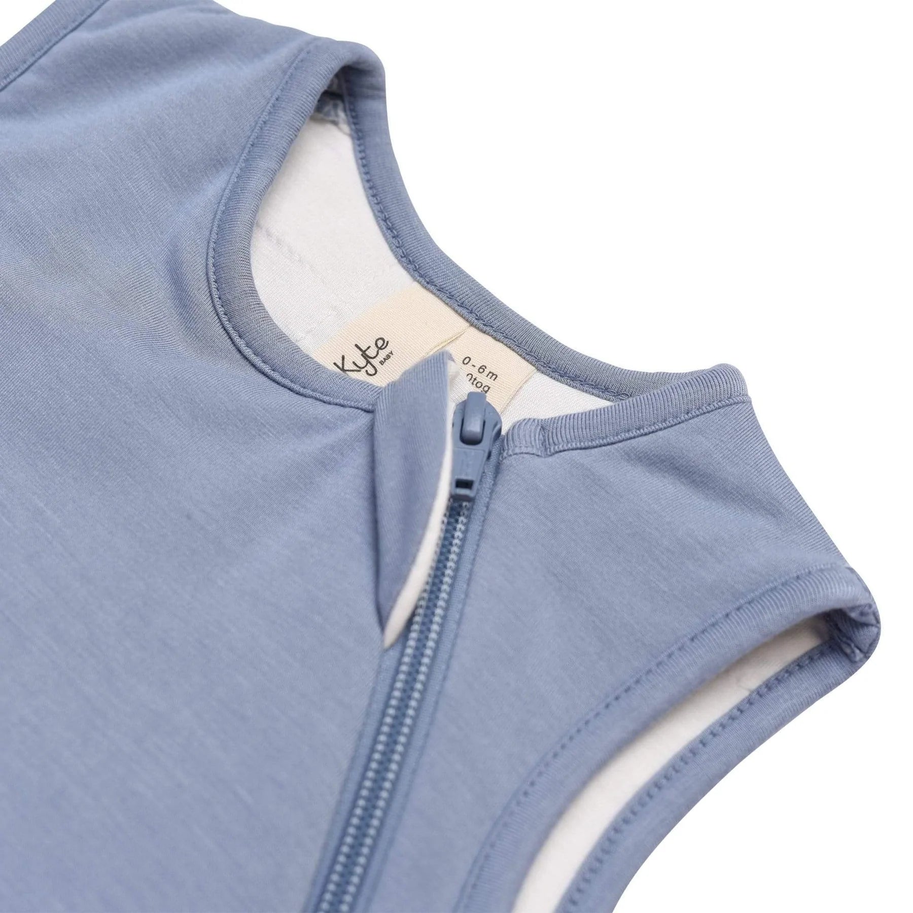 Detail of zipper with fabric cover at top of Kyte sleepsack in slate blue for baby sleep in 1.0 TOG weight with zipper opening in bamboo fabric