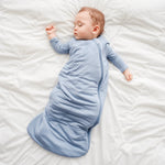 Baby sleeping in Kyte sleepsack in slate blue for baby sleep in 1.0 TOG weight with zipper opening in bamboo fabric